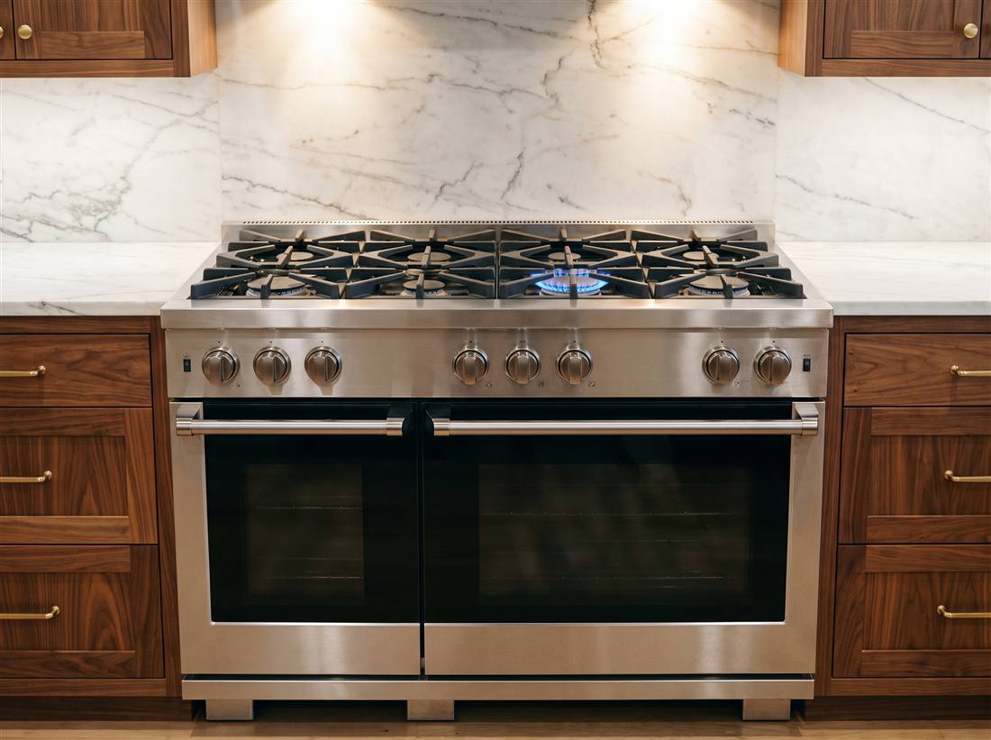 Professional stainless range with star-shaped burners, one lit blue